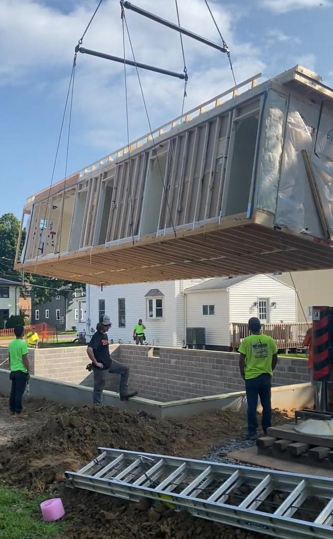 Crane moving modular home into place