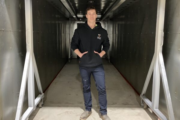 Nick Carleton stands just inside the 25-foot-x-8-foot-x-8-foot oven that will be used by soon-to-launch Paint Works to cure powder coatings on a variety of items, from backyard pergolas to classic cars. (Photo by Kevin Oklobzija)