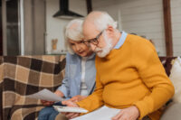 Elderly couple sitting and looking at documents (Depositphotos)