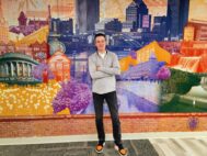 Brian Sabedra, PwC Rochester’s office managing partner, stands in front of a mural highlighting Rochester sites at its new headquarters at High Point Business Park in Victor. (Photo by Andrea Deckert)