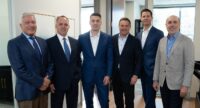 Lee Woodring (second from left) and Robert (Bobby) LeRoy (third from left) with the founders of Indivisible Partners at the recent grand opening of Woodring | LeRoy Capital Advisors’ local office. (Photo provided by WLCA)