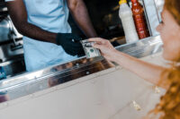 Woman handing cash after ordering by Depositphotos