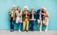 seniors lined up in front of light blue wall by Depositphotos
