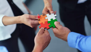 arms putting puzzle pieces together by Depositphotos
